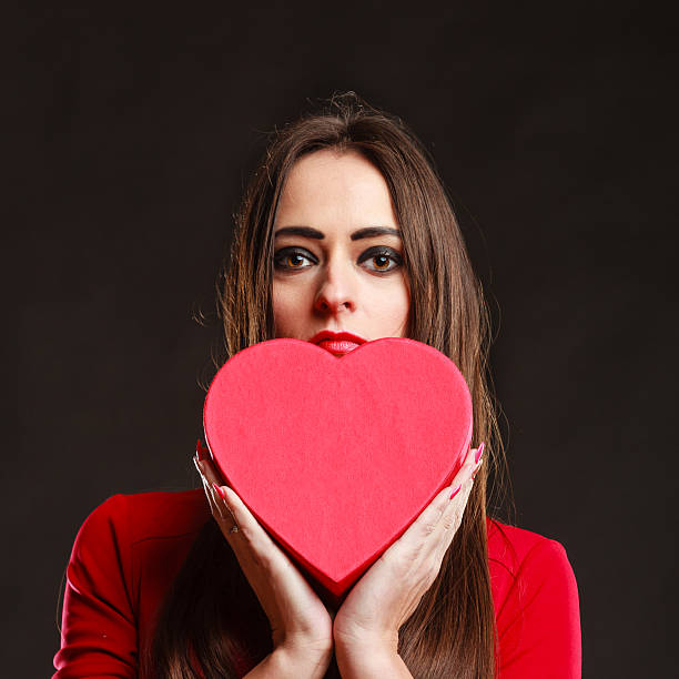 istock Girl in red holding heart box. 610949206