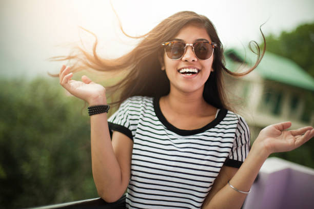 hermosa chica con gafas de sol disfrutando de aire fresco en el balcón. - teenage girls pretty smile looking at camera waist up fotografías e imágenes de stock