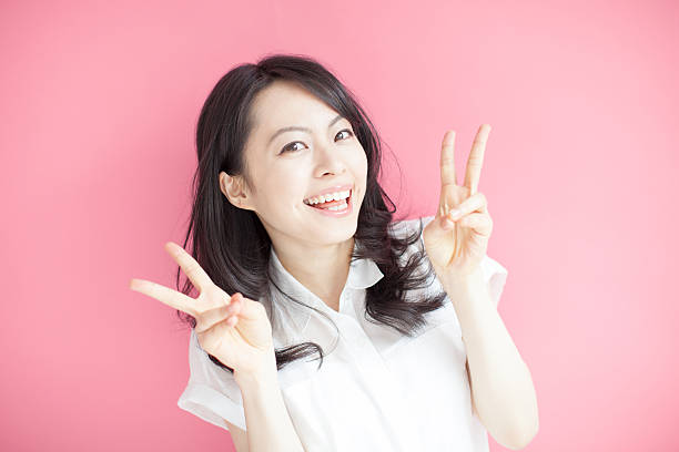 istock Japanese woman making gestures in pink background 610950776