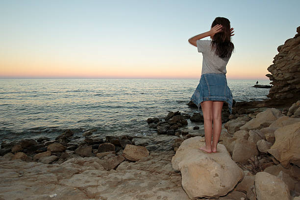 istock Girl meditating on a beach 610951394