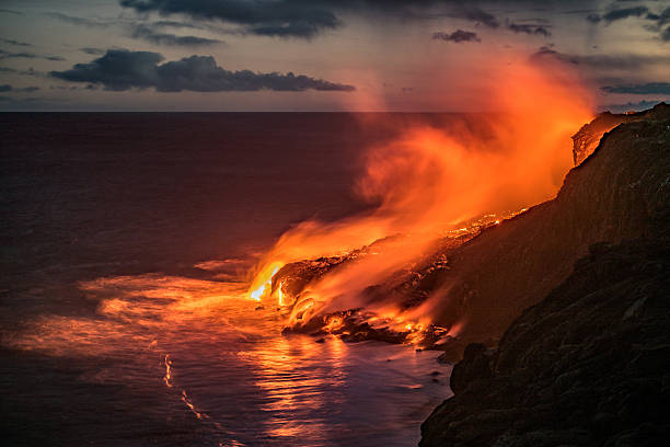 Hawaiian lava flow into the Pacific ocean Spectacular evening view of the lava from the Kilauea volcano, flowing in the Pacific ocean near Kalapana on the south coast of the Big Island of Hawaii. pele stock pictures, royalty-free photos & images