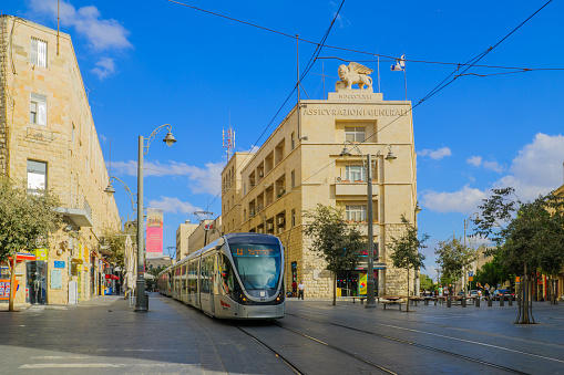 Jerusalem, Israel - September 23, 2016: Scene of Yafo Street, with the Generali building, a tram, locals and visitors, in Jerusalem, Israel