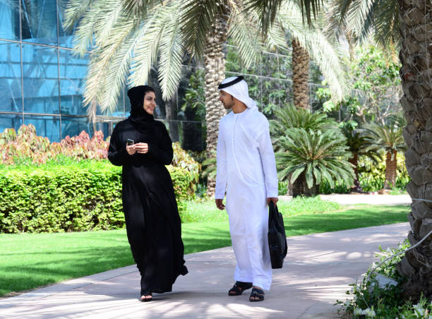istock Arab businessman and woman having conversation, walking 610953468