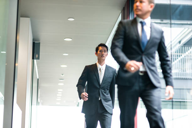 istock japanese Businessmen walking on the office corridor 610954734