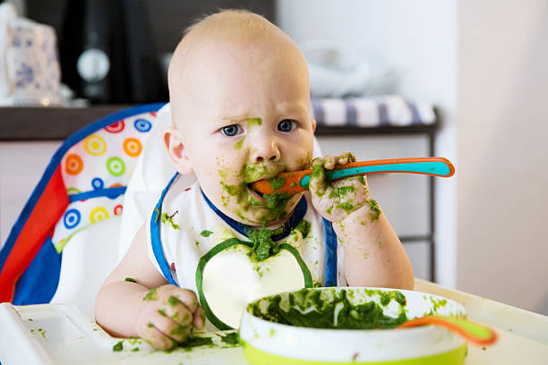 alimentación. el primer alimento sólido del bebé - baby food fotografías e imágenes de stock