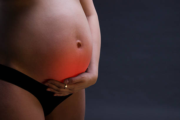 femme enceinte de race blanche en lingerie noire avec douleur abdominale - frustration women threats disappointment photos et images de collection