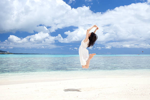istock Japanese woman jumping on the beach 610957080