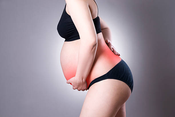 femme enceinte caucasienne en lingerie avec douleurs au dos et abdominales - frustration women threats disappointment photos et images de collection