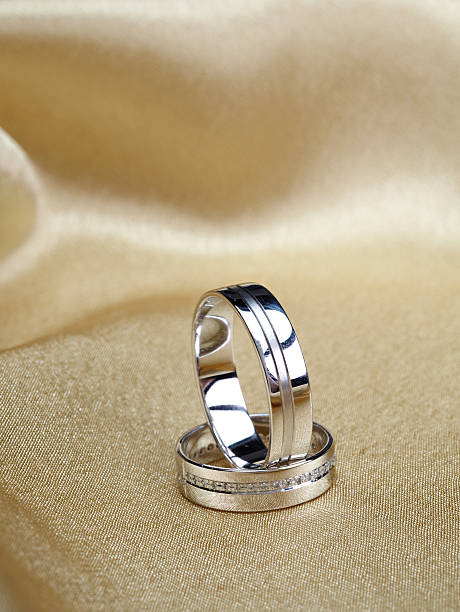 istock Wedding bands on golden satin 610960968