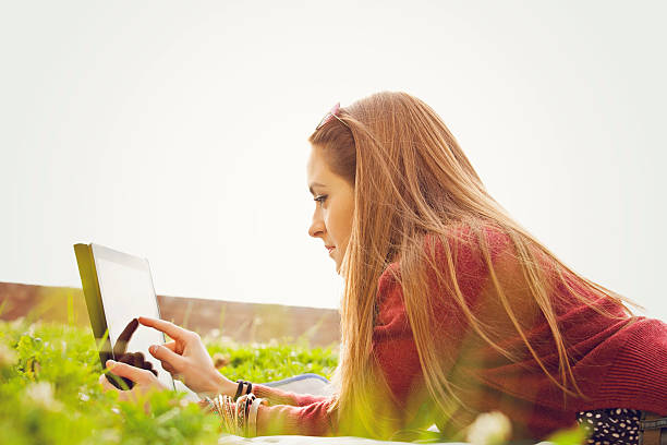 istock Young woman with a tablet outside 610961316