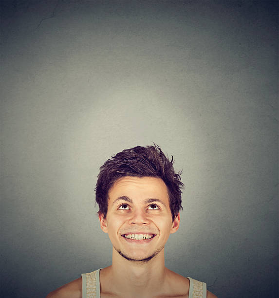 istock Portrait handsome smiling young man looking up 610962436
