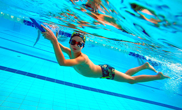 istock Six year old boy swims and dives in the pool 610963700