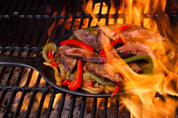 istock Beef, Chicken and Shrimp Fajitas Cooking on a Grill 610969100