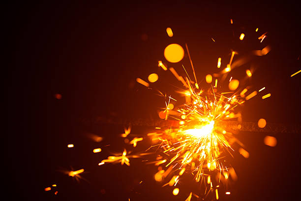 Christmas sparkler in haze with red light Christmas sparkler in haze with red light, New Year background lighting fire cracker stock pictures, royalty-free photos & images