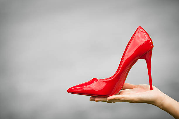 istock Hand holding red high heel shoe 610970428