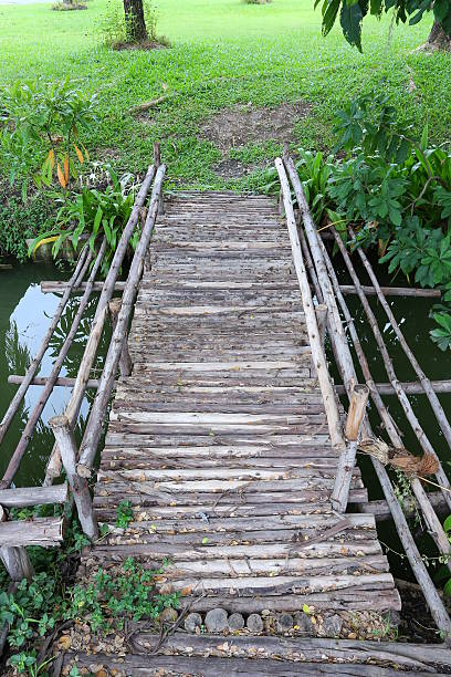 istock Wooden bridge across a pond 610972526
