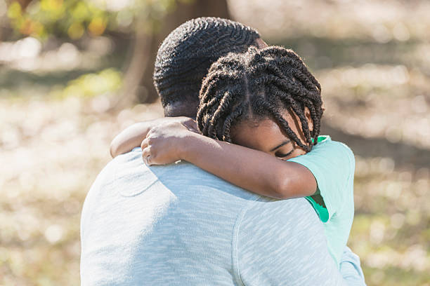 istock Little African American boy hugging father 610973614