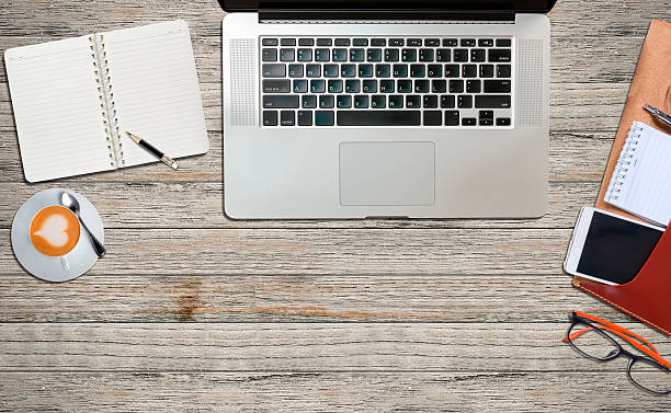 istock laptop and office supplies  on a wooden table 610973854