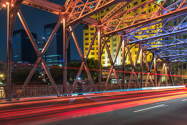 istock blurred traffic light trails on road with cityscape 610978810