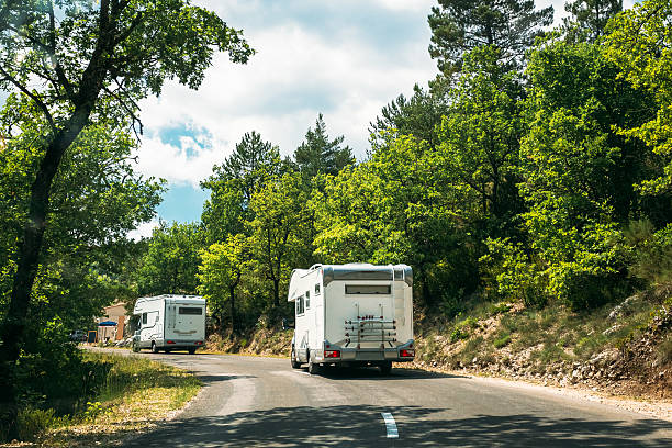 Motorhome Car Goes On Road On Background Of French Mountain White Colour Motorhome Car Goes On Road On Background Of French Mountain Nature Landscape. rv manufacturing stock pictures, royalty-free photos & images
