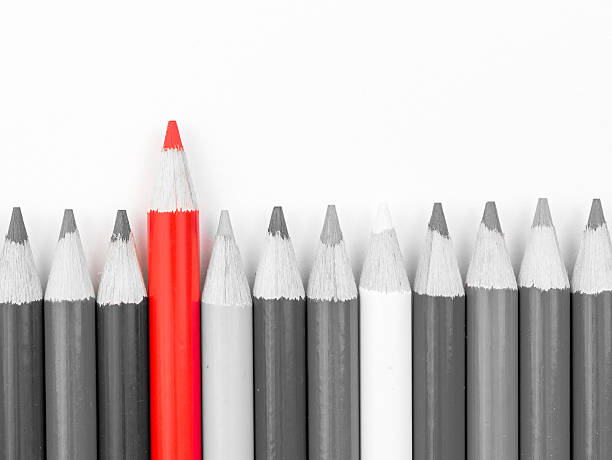 istock Red pencil standing out from monochrome pencils crowd 610982246