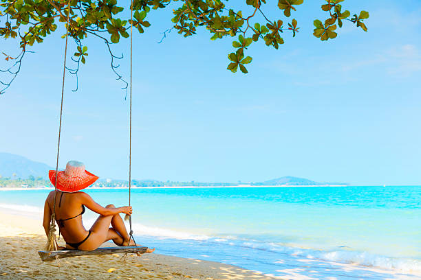 Woman sitting at tropical swing