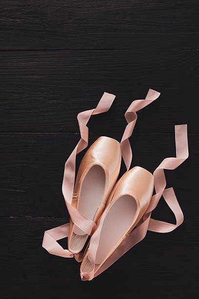 istock Pink ballet pointe shoes on black wood background 610983724