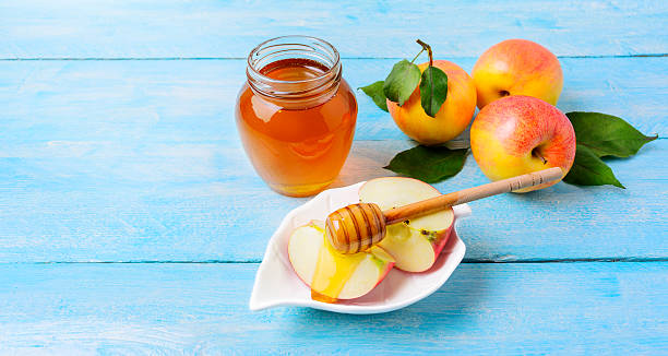 istock Honey jar and apple slices with honey on blue background 610984882