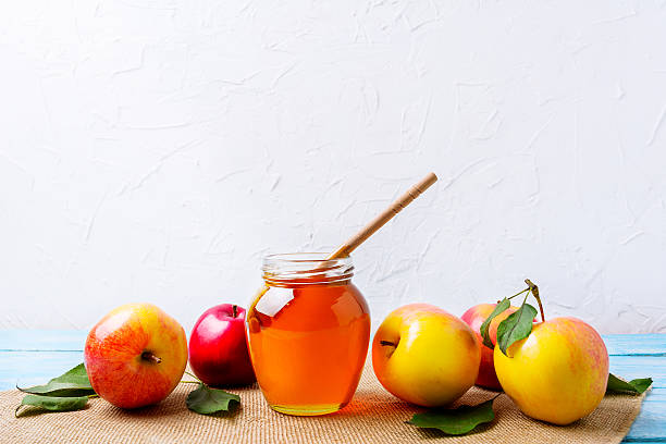 istock Honey jar with dipper and apples on white background 610984926