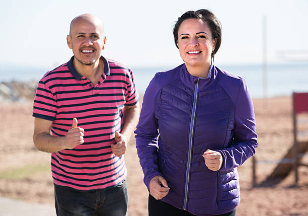 istock Mature couple jogging together 610986380