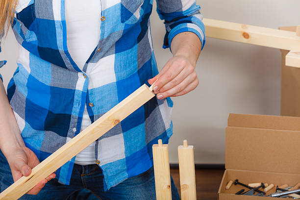istock Human assembling wood furniture. DIY. 610988584