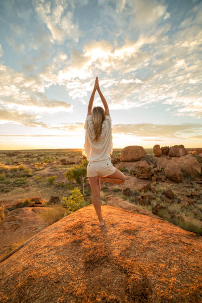 la femelle sur rocher exerce le yoga au lever du soleil - emu australia northern territory outback photos et images de collection