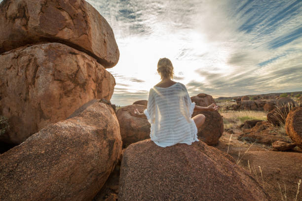 istock Caucasian female on spheric boulder exercises yoga 610989788