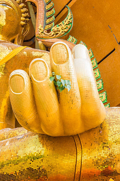 istock Gold hand big buddha statue bodhi tree leaves 610989942