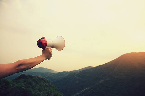 istock hand hold loudspeaker to blue sky on mountain peak 610990370