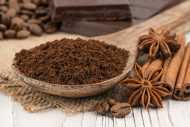 istock Ground coffee in a wooden spoon on  white wooden table. 611062568