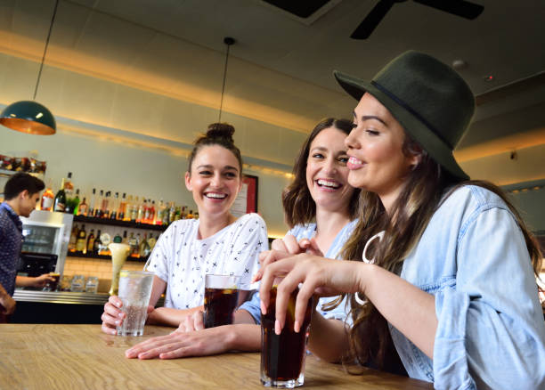 istock Young women in bar, guy ordering 611064334