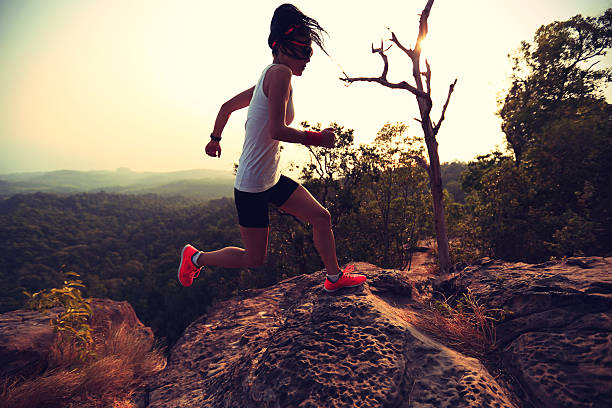 istock young asian woman runner running on mountain peak 611064588