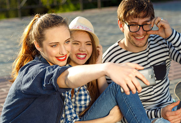 istock Smiling friends making selfie outdoors 611064670