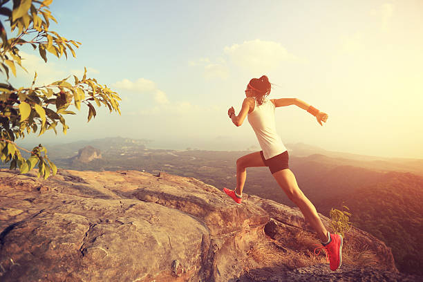 istock young asian woman runner running on mountain peak 611065348