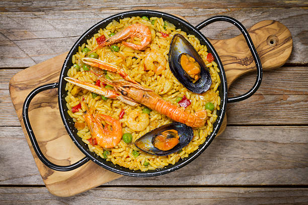 istock Spanish paella on a wooden table 611065366