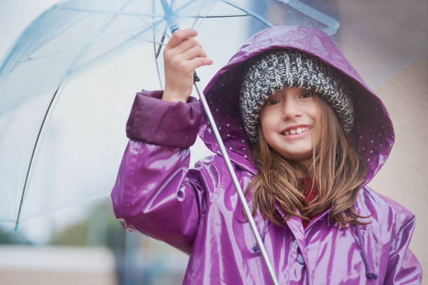 The cold never bothered me anyway Portrait of a little girl standing under an umbrella outside anyway stock pictures, royalty-free photos & images