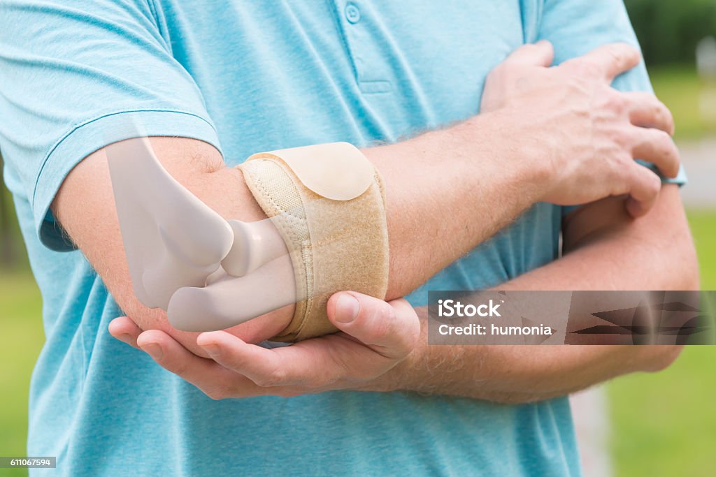 Man wearing elbow brace Man wearing elbow brace to reduce pain Elbow Stock Photo