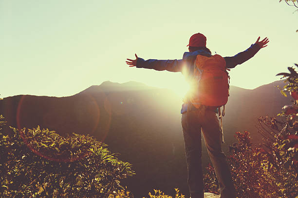 istock successful woman hiker open arms on sunrise mountain peak 611067602