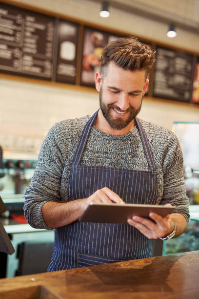 istock Replying to comments from customers on his social media 611069492