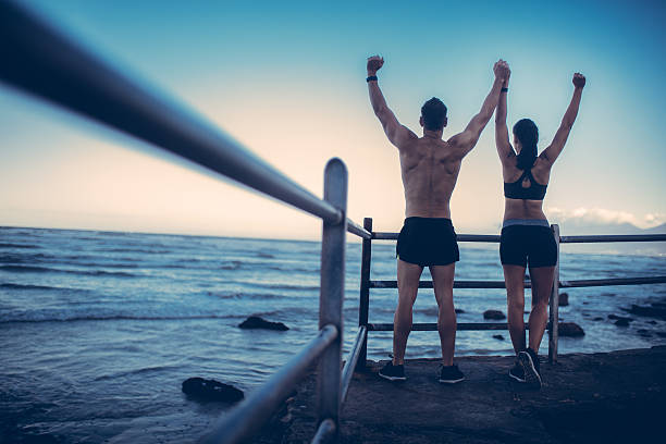 istock Fitness Couple doing conquering pose after Run at the beach 611070200