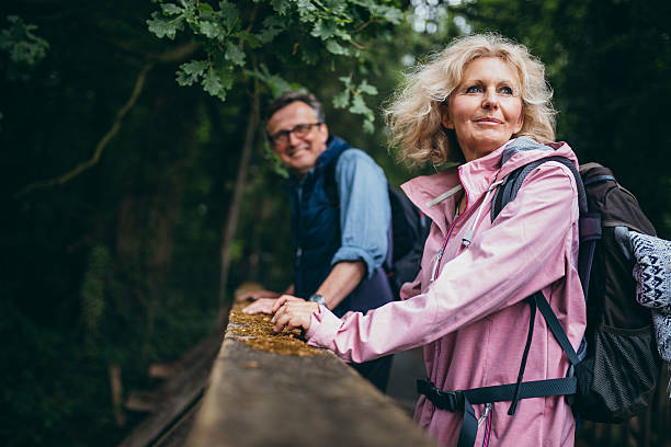 senior couple enjoying hike in the forest - retirement living imagens e fotografias de stock