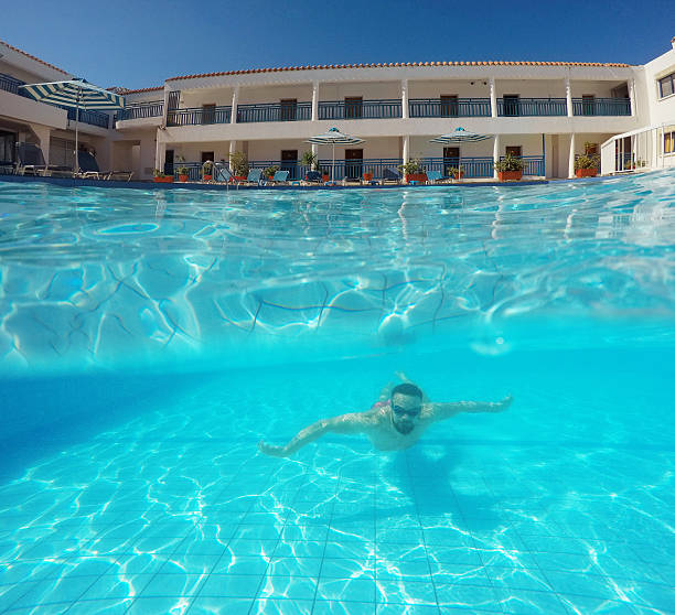istock Beard man with glasses swimming under water in the pool 611071944