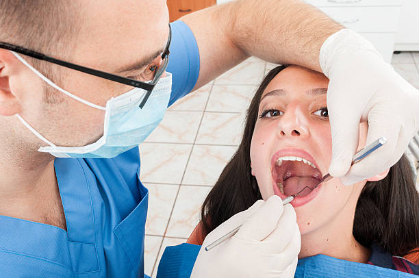 istock Lady sitting in dentist chair being checked by doctor 611072954