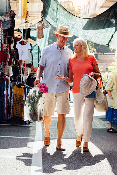 pareja de ancianos que viste un mercado al aire libre - couple mature adult europe travel fotografías e imágenes de stock